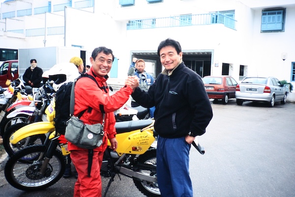 チュニス港でのバイクの引き取り完了。道祖神の菊地さんと握手！